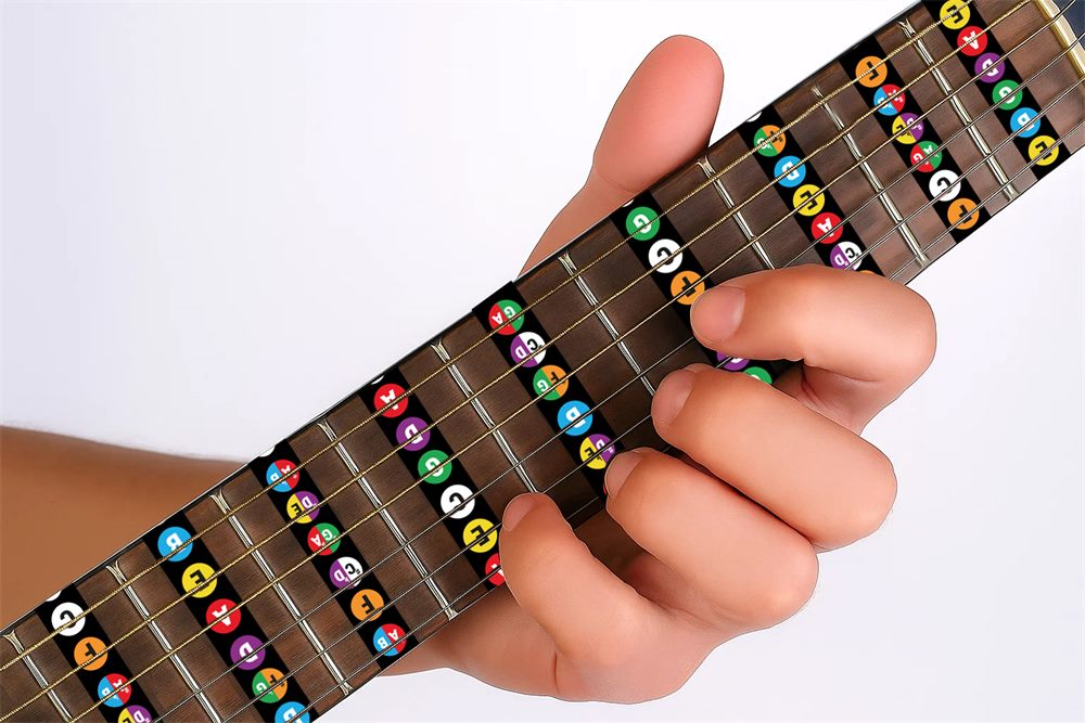 Mano tocando una guitarra con stickers de notas en el diapasón